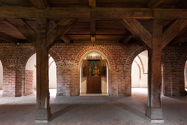 In einer Nische des Backsteingewölbes wurde Raum geschaffen für zwei hölzernen Darstellungen.