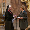 Zwei Frauen stehen sich in einer Kirche gegenüber.