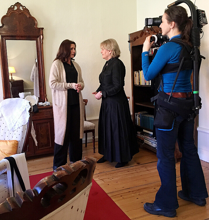 Eine Frau interviewt Dr. Kristin Püttmann, Äbtissin des Klosters Medingen, und die beiden werden dabei gefilmt.