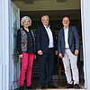 Drei Personen stehen in einem Eingangsbereich.