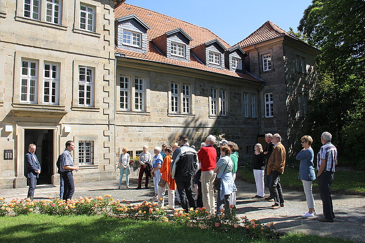 Eine Gruppe von Personen, darunter Dr. Tim Wameling, Baudezernent der Klosterkammer, steht vor dem Kloster Barsinghausen.