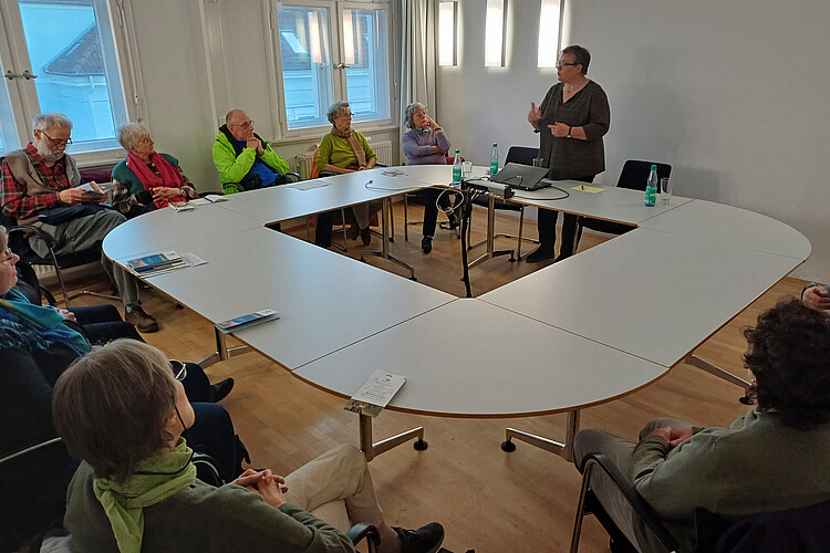 Die Äbtissin Ulrike Kempe spricht vor einer Gruppe von zehn Personen in einem Konferenzraum der Klosterkammer über das Wohnen im alter im Kloster Marienwerder.