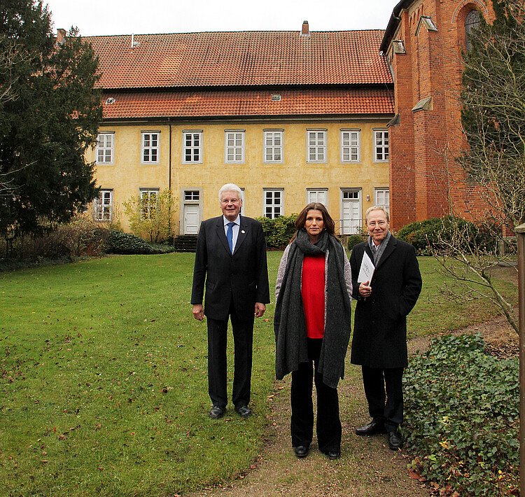 Eine Frau und zwei Männer, darunter Klosterkammer-Präsident Hans-Christian Biallas, stehen vor dem Kloster Mariensee.