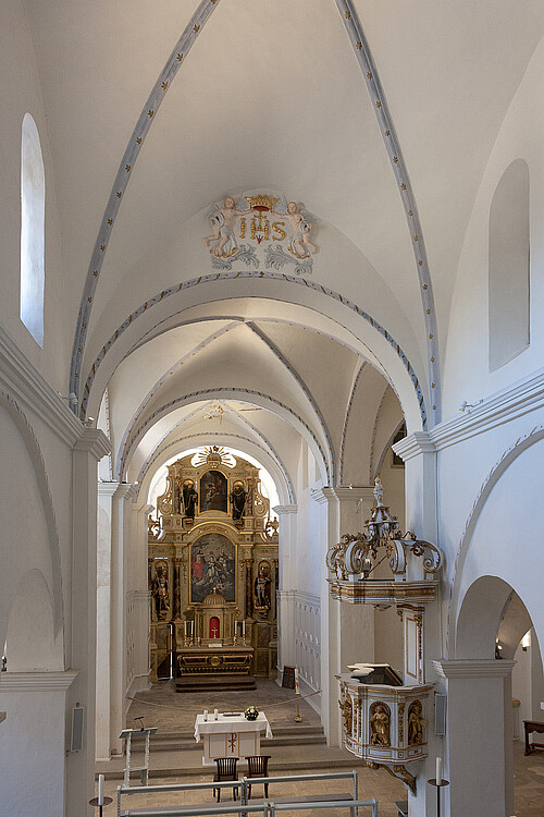 Der hell gestaltete Innenraum einer Kirche mit teilweise goldener Verzierung.