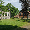 Zu sehen sind zwei historische Gebäude, die zum Klostergut Burgsittensen gehören. Sie sind von einer ebenfalls denkmalgeschützten Parkanlage umgeben.