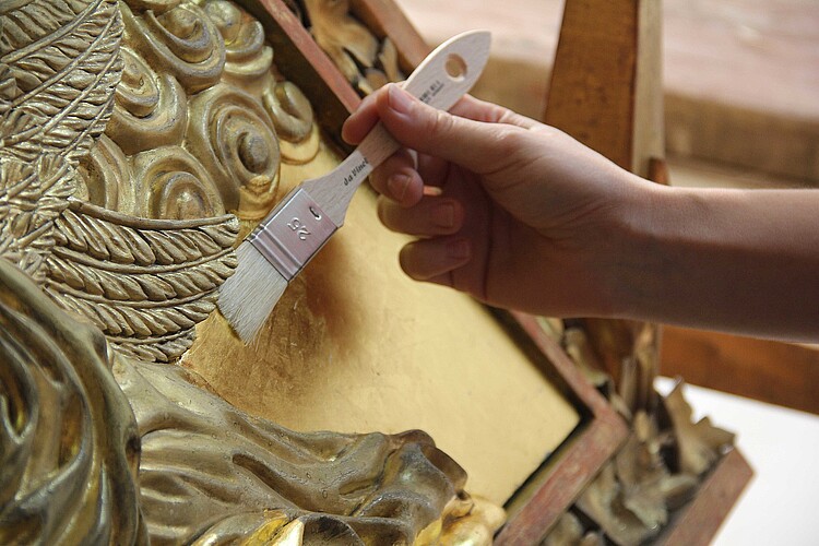 Hochaltar im Dom Verden: Eine Hand mit einem Pinsel auf einem Relief.