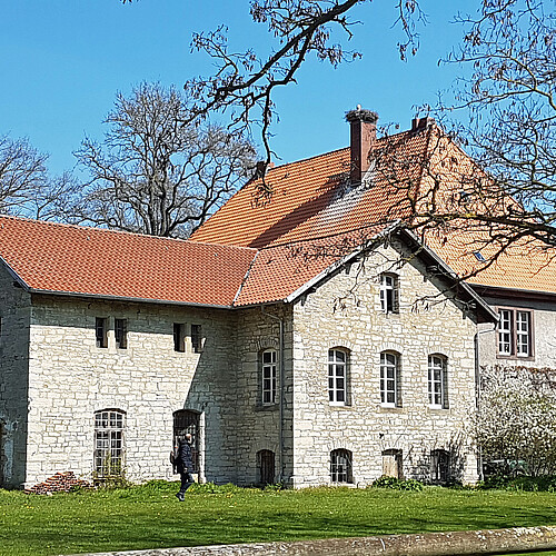 Das Molkehaus auf dem Klostergut Wiebrechtshausen mit heller Fassade und roten Dachziegeln.