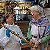 Zwei Frauen stehen in der Klosterkirche Lüne vor einem Gerüst. Eine der beiden trägt einen weißen Schutzanzug und hält einen goldfarbenen Kunstgegenstand in der Hand.