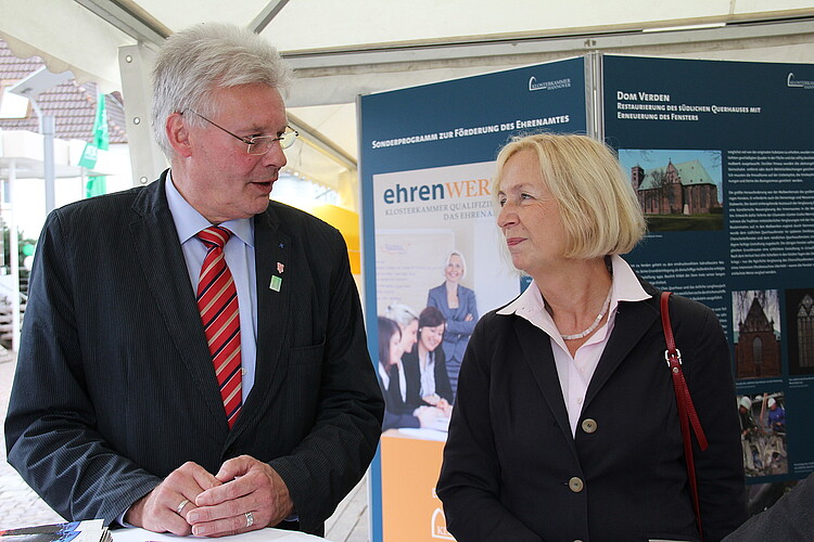 Ein Herr und eine Dame stehen nebeneinander vor einer Informationstafel.