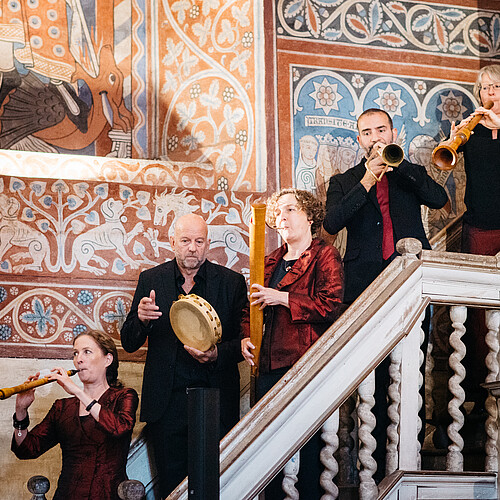 Fünf Personen, die Musikinstrumente spielen, stehen auf einer Treppe im Kloster Wienhausen.