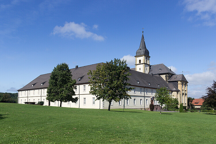 Der Gebäudekomplex des ehemaligen Klosters Grauhof bei Goslar in barockem Stil, im Hintergrund ragt ein Kirchturm hervor.