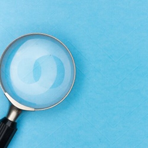 Symbolbild mit Lupe mit schwarzem Griff auf hellblauem Hintergrund