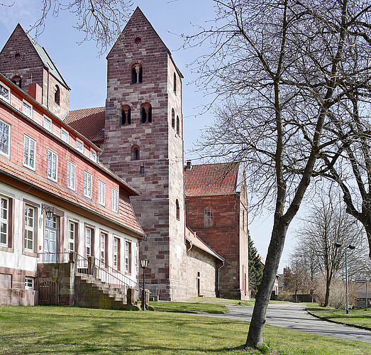 Eine gotische Kirche in Bruchsteinoptik mit zwei schlichten Türmen.