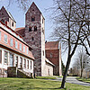 Eine gotische Kirche in Bruchsteinoptik mit zwei schlichten Türmen.