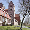 Eine gotische Kirche in Bruchsteinoptik mit zwei schlichten Türmen.
