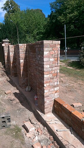 Ziegelsteine werden bei einem Teilstück der Mauer neu aufgebaut.