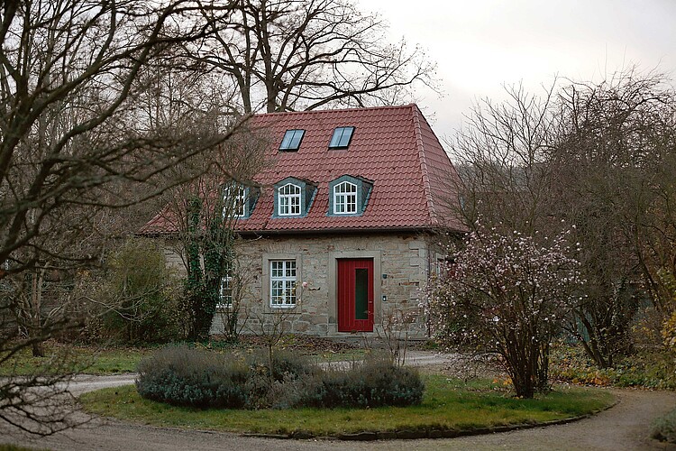 Ein Gebäude aus Stein mit roter Eingangstür auf dem Gelände des Klosters Barsinghausen.