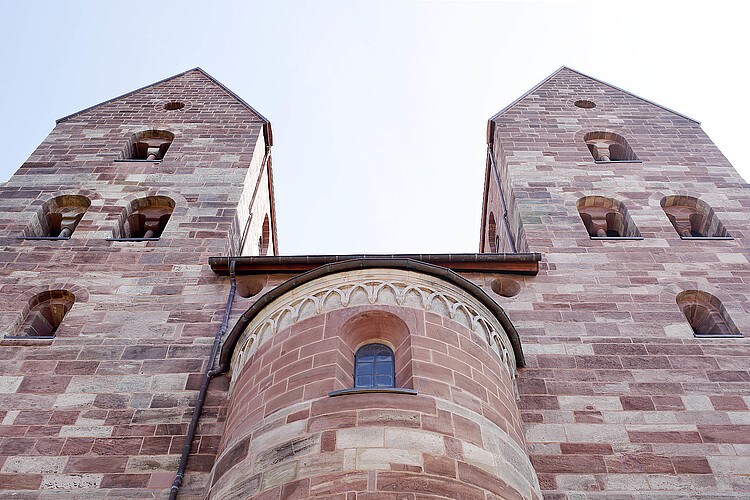 Zwei schlichte Türme einer gotische Kirche in Bruchsteinoptik.