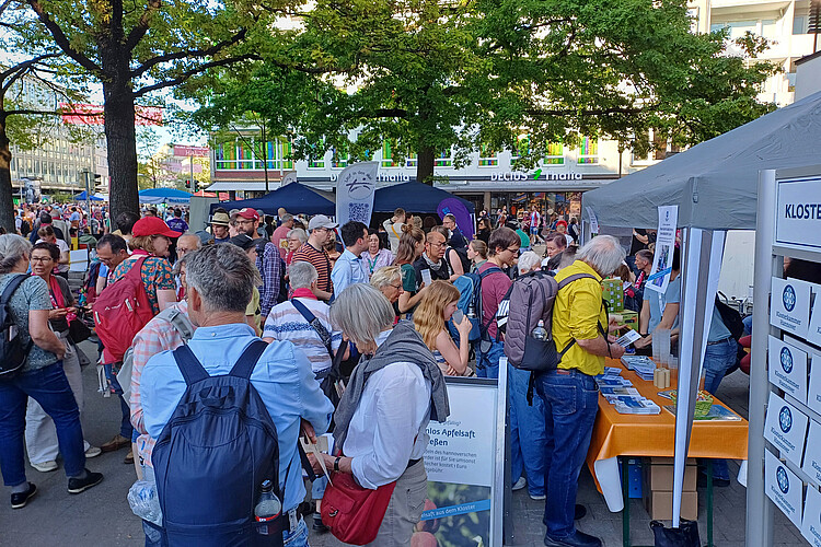 Menschen stehen vor einem Stand in der Innenstadt an