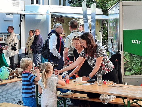 Kinder und Erwachsene stehen an einem Stand im Hof der Klosterkammer