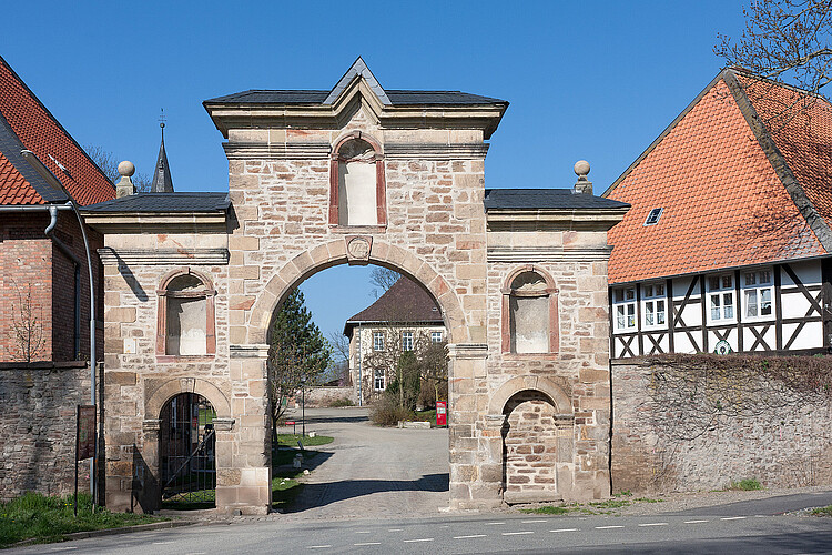 Ein Torbogen aus hellem Stein, der restauriert worden ist.