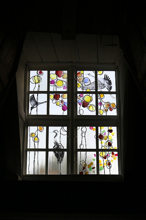 Nahaufnahme eine modernen Glasfensters im Kloster Lüne, das sich im Obergeschoss des Westflügels befindet.