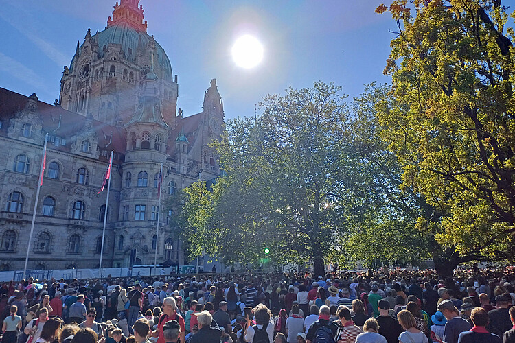 Eine Menschenmenge bei Sonnenschein vor dem Neuen Rathaus