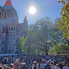 Eine Menschenmenge bei Sonnenschein vor dem Neuen Rathaus