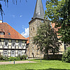 Bilck auf eine Kirche in einem parkähnlichen Garten.