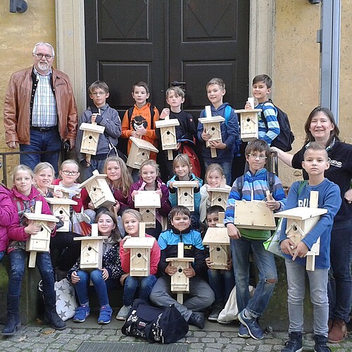 Kinder mit Vogelnistkästen