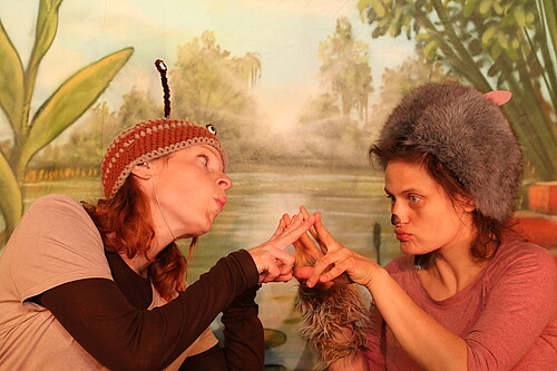 Zwei Frauen in Kostümen schauen einander an.