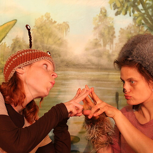 Zwei Frauen in Kostümen schauen einander an.