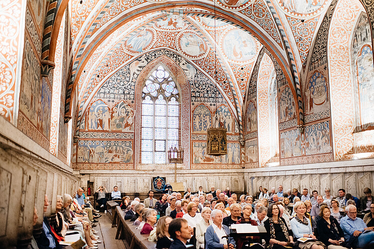 Der Nonnenchor im Kloster Wienhausen ist während eines Konzertes voll besetzt. Es handelt sich um einen hohen Raum, der mit kunstvollen Malereien verziert ist.