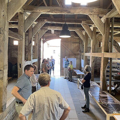 Blick in den Innenraum der Südscheune des Stift Fischbeck am Tag der Architektur 2022. Klosterkammermitarbeiter Dr. Tim Wameling erklärt Besucherinnen und Besuchern, was die Bauabteilung dort rekonstruiert hat.