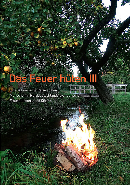 Die Titelseite des Klostermagazins zeigt eine Schale mit brennenden Holzscheiden neben einen Bach und unter einem Apfelbaum.
