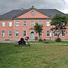 Frontaler Blick auf die Fassade des historischen Gebäudes in einem kräftigen Rot.