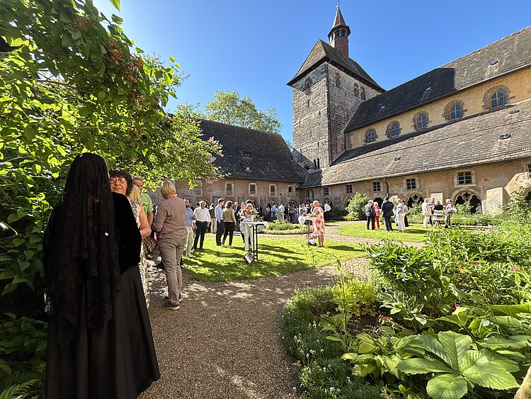 Ein Klosterhof mit Menschen.