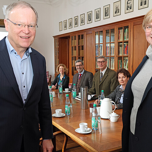Zwei Personen stehen im Vordergrund, der Ministerpräsident Stephan Weil und die Klosterkammer-Präsidentin Dr. Thela Wernstedt. Im Hintergrund sitzen vier Personen.