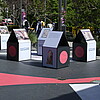 Großformatige Boxen mit unterschiedlichem Aufdruck bilden eine Ausstellung
