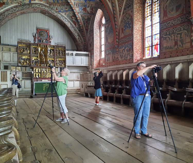 Ausschnitt des ausgemalten Nonnenchors im Kloster Wienhausen, vier Frauen mit Kameras und Stativen.