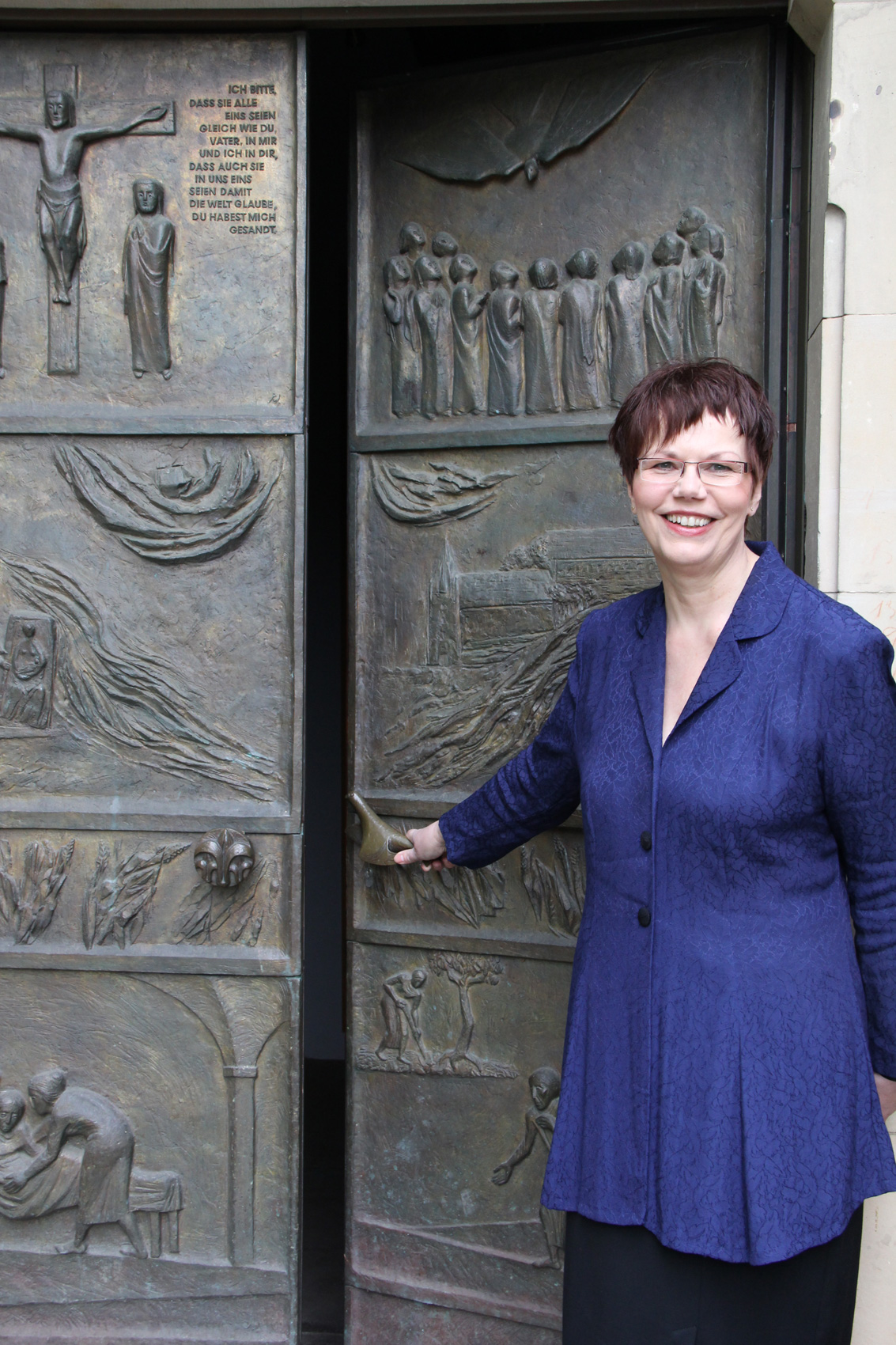 Eien Frau steht im leicht geöffneten Portal der Klosterkirche Marienwerder und schaut in die Kamera. Eien Frau steht im leicht geöffneten Portal der Klosterkirche Marienwerder und schaut in die Kamera.