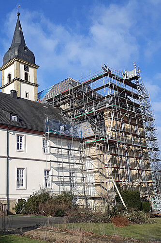 Eine Seite der hellen Fassade der Stiftskirche Grauhof ist eingerüstet.